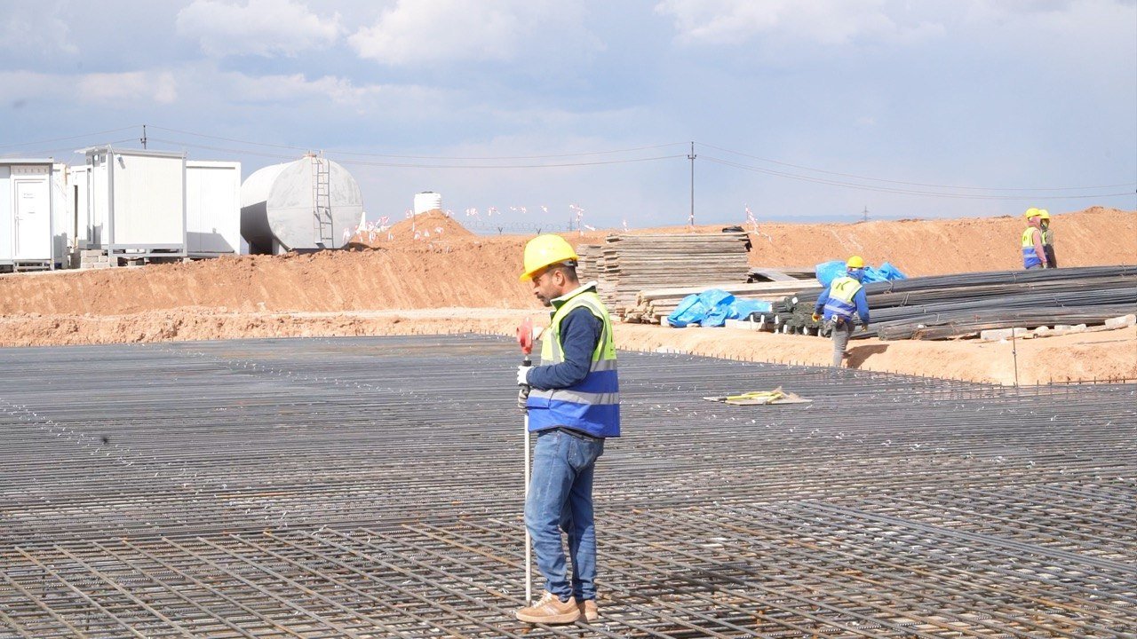 A site worker checking levels across reinforcement steel