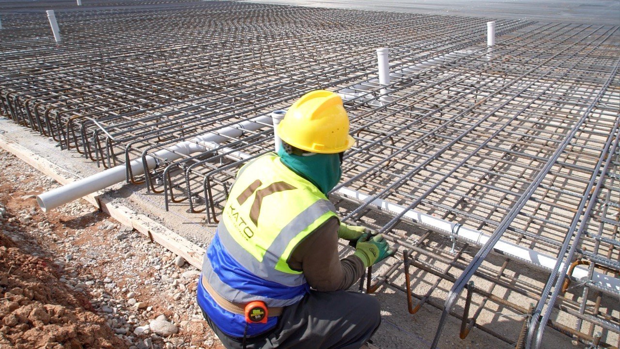 A KATO worker fixing reinforcement beside embedded pipework