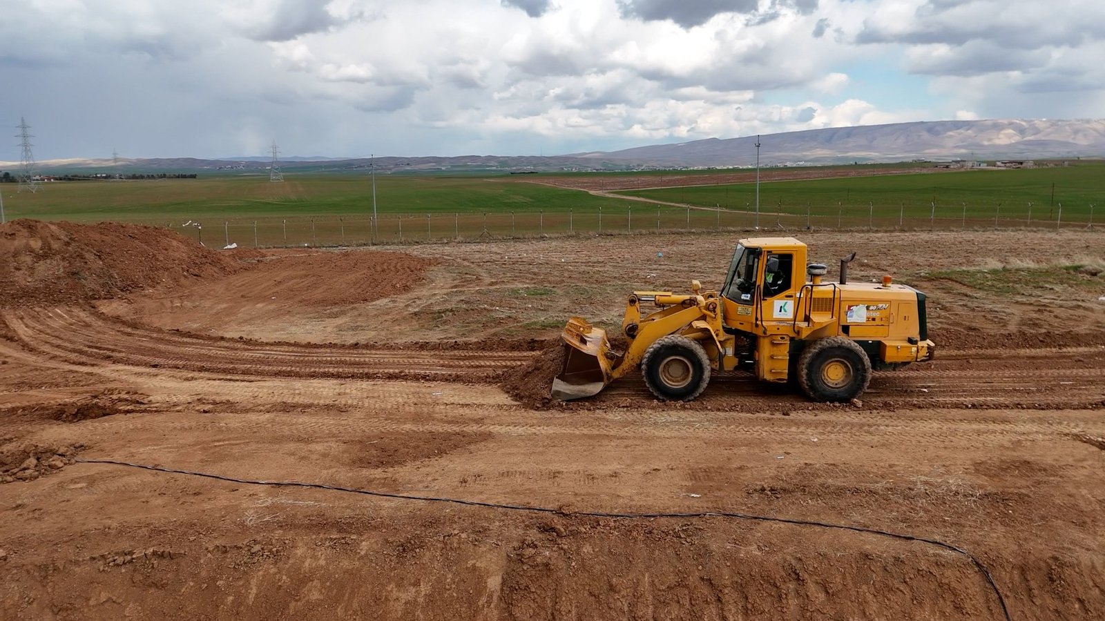A KATO wheel loader shaping the ground at a construction site
